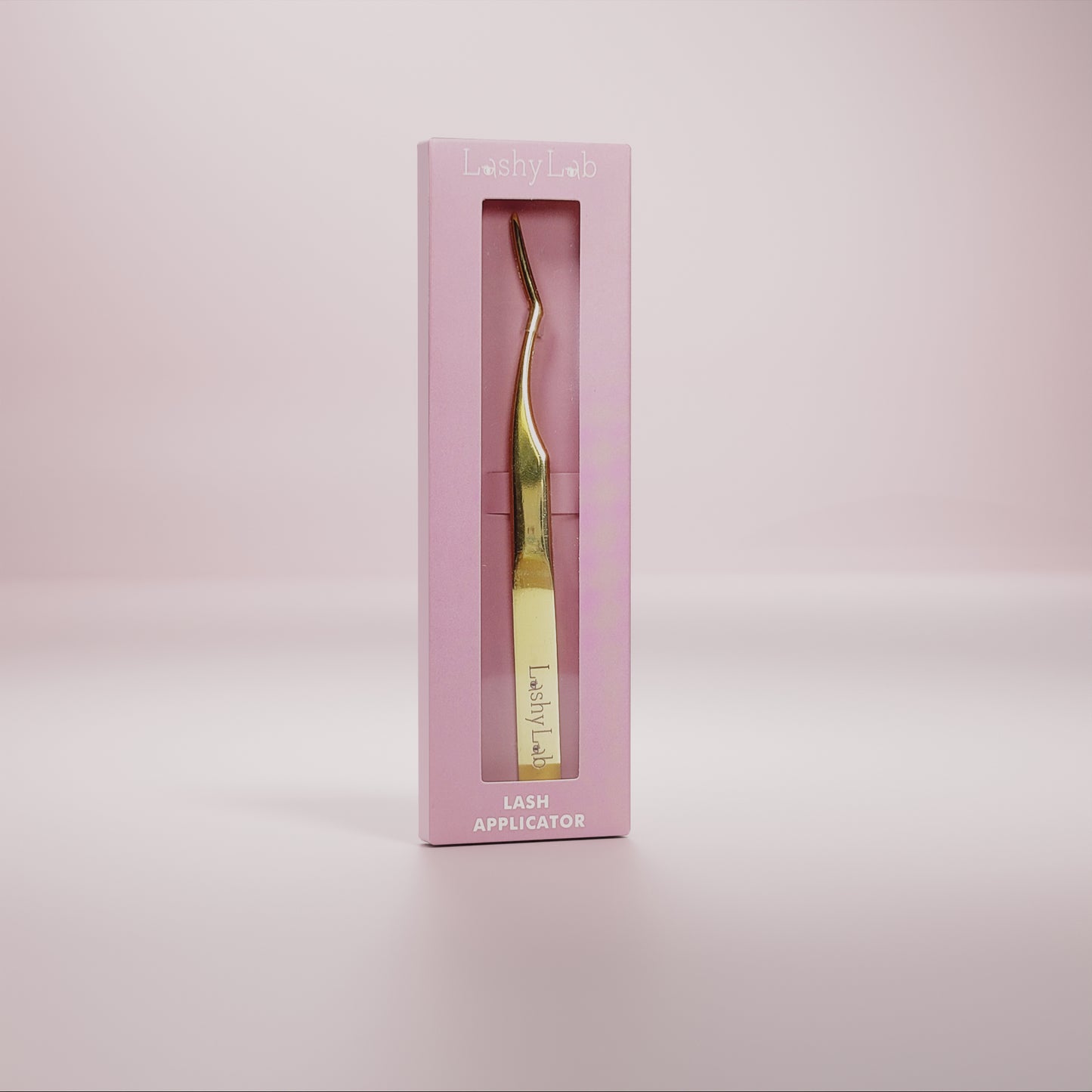 Lash applicator by Lashy Lab stands in a pink box against a soft pink background—ideal for easy, mess-free DIY eyelash extensions.