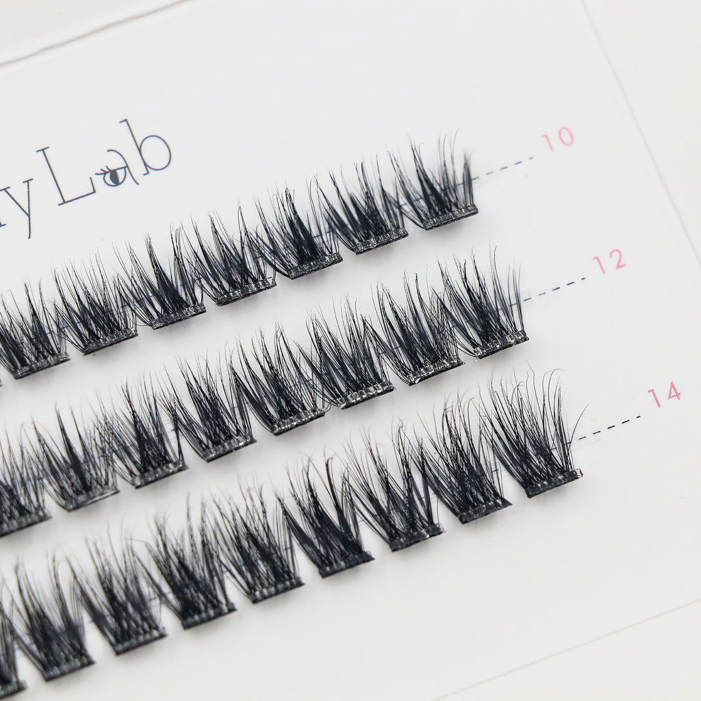 Close-up of Lashy Lab SASSY PRE-GLUED LASHES SET, featuring a white tray with multiple rows of neatly arranged black cluster lashes for DIY eyelash extensions.