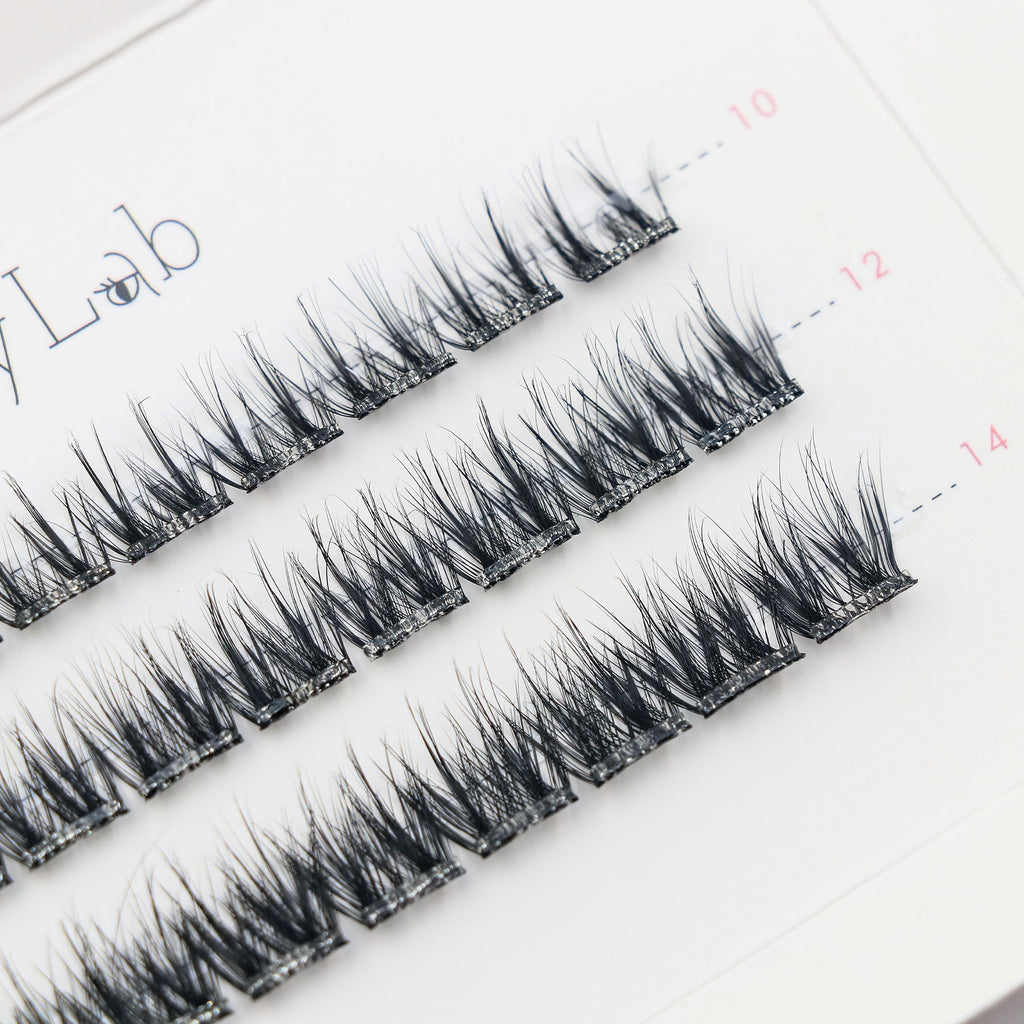 Close-up of Lashy Lab SIREN PRE-GLUED LASHES SET, featuring a white tray with multiple rows of neatly arranged black cluster lashes for DIY eyelash extensions.