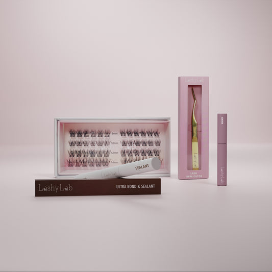 The Lashy Lab PRO CLUSTER LASHES STARTER BUNDLE offers easy at-home lash application, with underlash extensions, ultra bond & sealant, angled tweezers, and a mascara-like tube—all pictured on a soft pink background for lashes that last weeks.
