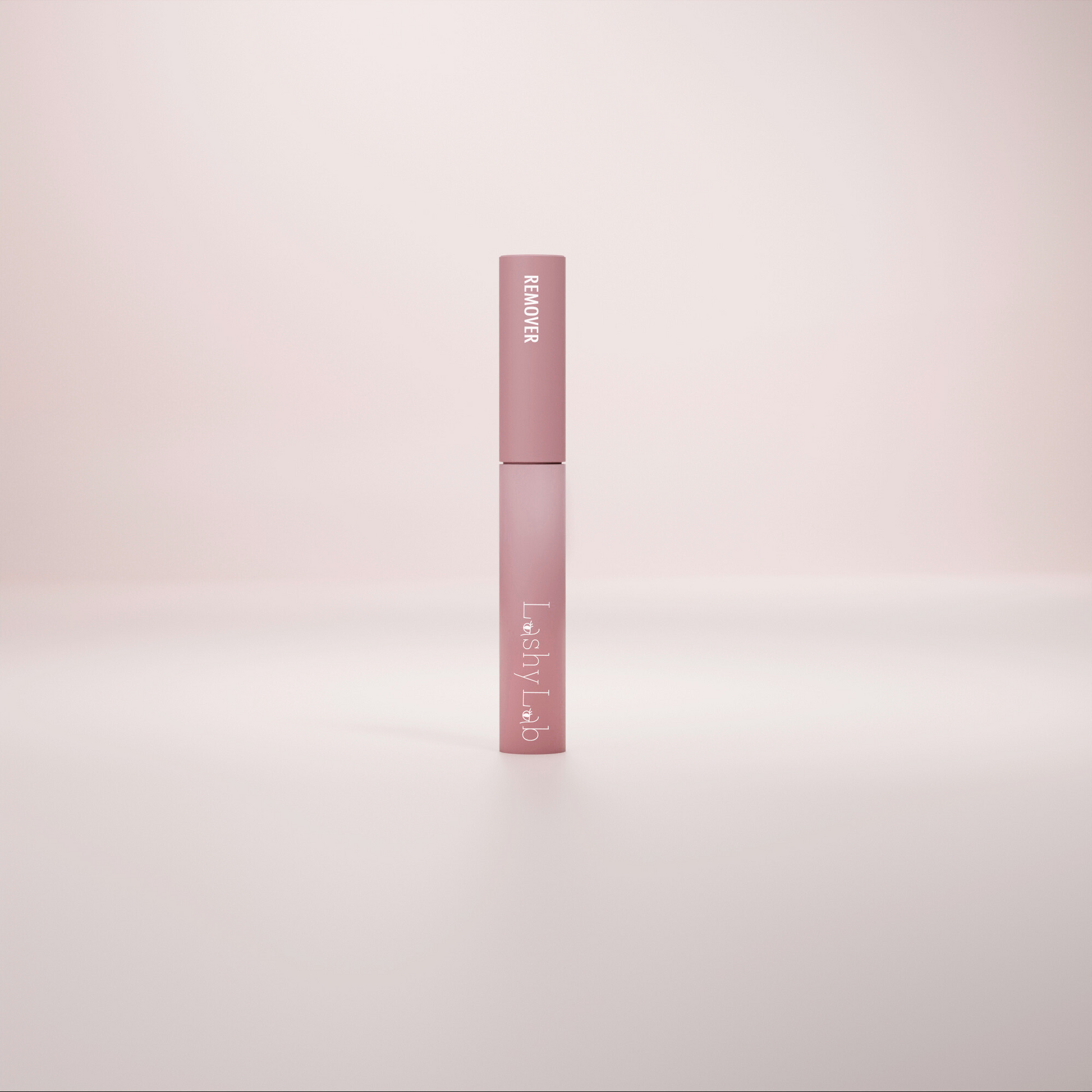 A pink tube labeled Lashy Lab LASH OFF REMOVER stands upright on a softly lit background, its minimalist design highlighting its use for cluster lashes against a gentle gradient backdrop.