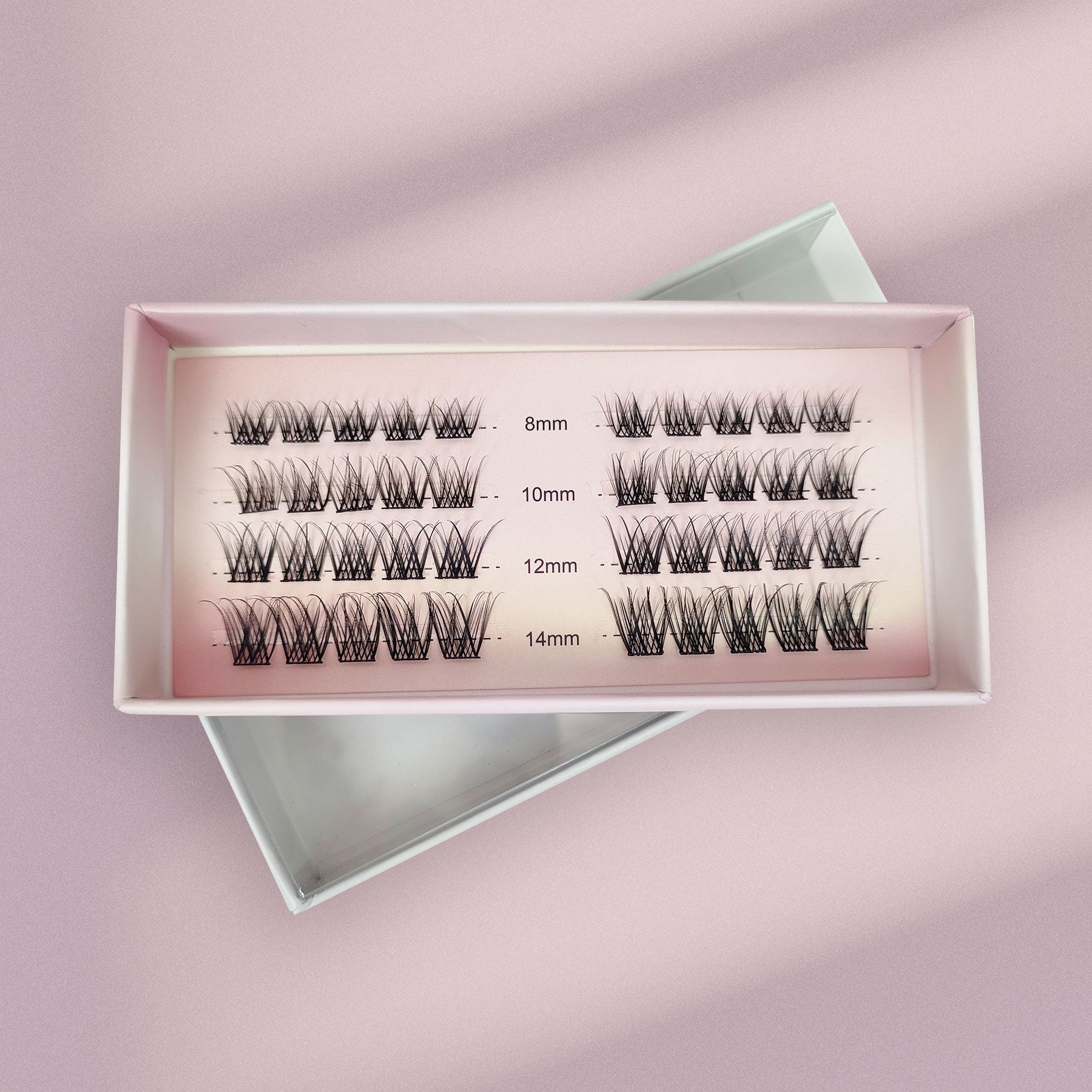 Lashy Labs CLASSIC FRENCH cluster lashes in four rows (8mm, 10mm, 12mm, 14mm) are displayed on a pink surface—Natural, Soft, Timeless beauty for DIY eyelash extensions that last weeks.