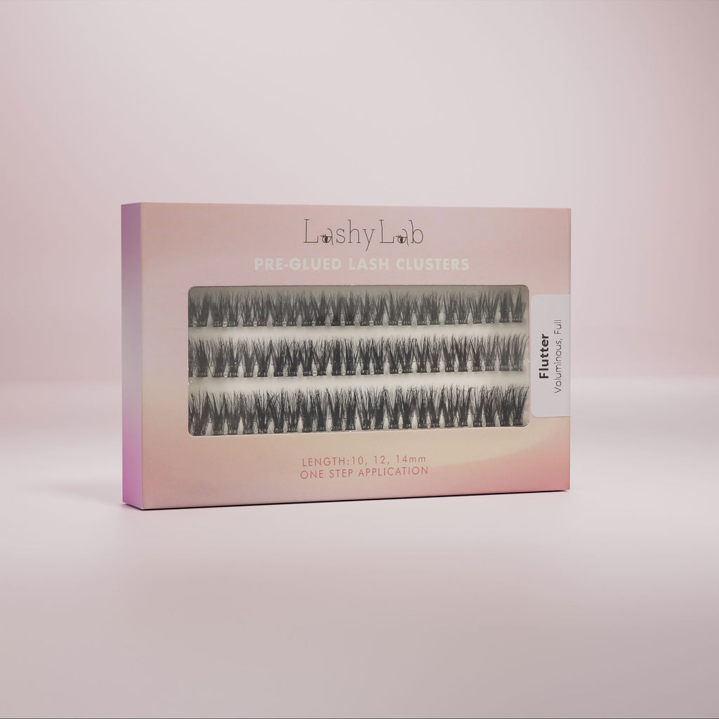 Lashy Lab’s FLUTTER set features pre-glued lashes in three lengths—8mm, 10mm, 12mm—for effortless, natural beauty. The lashes are arranged in rows and displayed against a pink background.