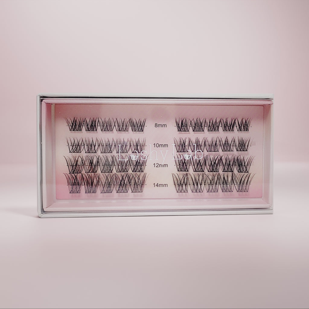 The MOONLIGHT - Subtle, Light, Flare from Lashy Lab features a box of DIY eyelash extensions in 8mm, 10mm, 12mm, and 14mm lengths, neatly arranged in transparent packaging for easy application and lasting wear on a pink background.